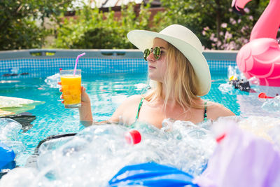 Midsection of woman sitting by swimming pool