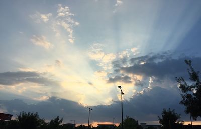 Low angle view of silhouette street light against cloudy sky