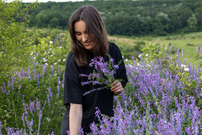 Young woman standing amidst flowers