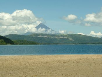 Scenic view of sea and mountains against sky