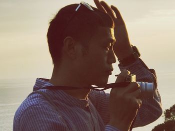 Portrait of young man drinking water from beach