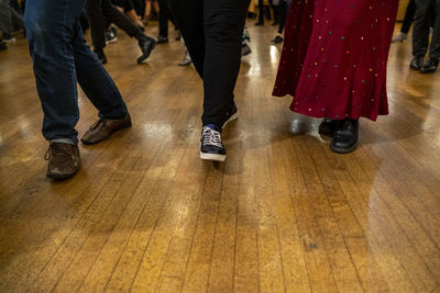 Low section of people on wooden floor