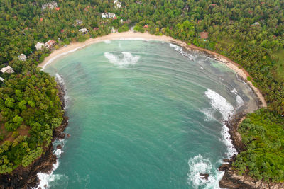 Hiriketiya beach and surfers in the sea, a famous surfing spot in sri lanka.