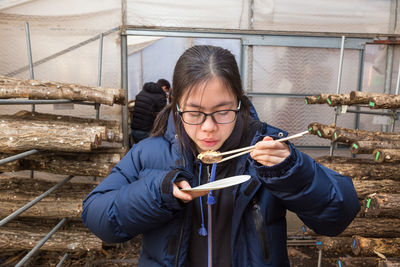 Girl eating food with chopsticks