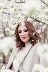 Beautiful girl in a dress walking in a blooming garden