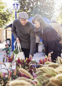 Young couple choosing flowers at market