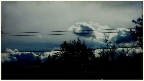 Low angle view of power lines against sky