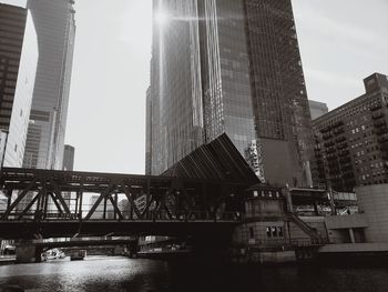 Bridge over river against buildings in city