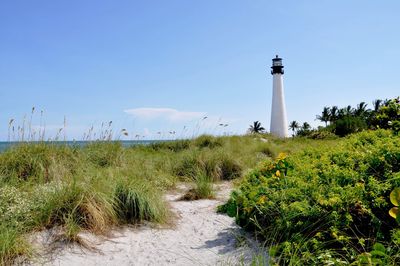 Lighthouse on field against clear sky