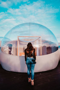 Rear view of woman standing against sky