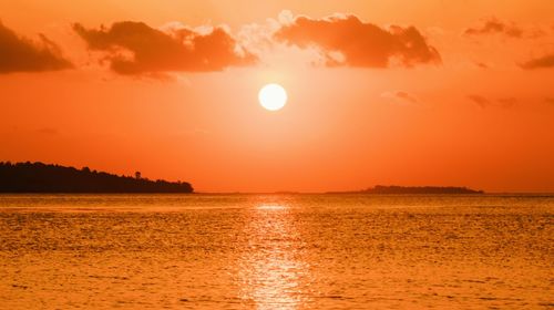 Scenic view of sea against orange sky