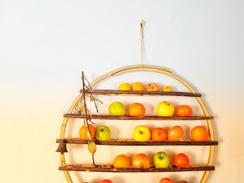 Multi colored fruits in container against wall