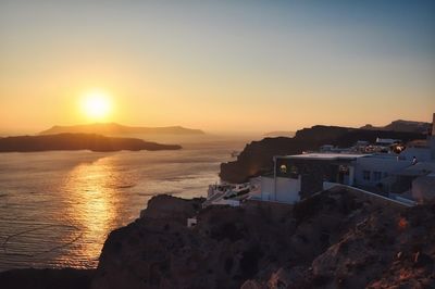 Scenic view of sea and buildings against sky during sunset