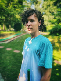 Portrait of young man standing against trees