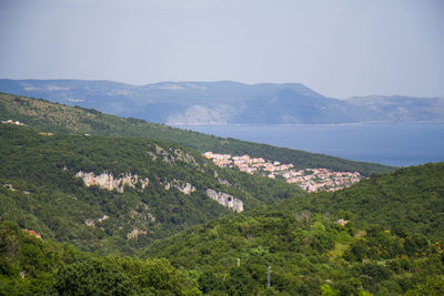 Scenic view of sea and mountains against sky