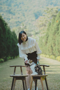 Side view of young woman sitting on bench