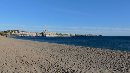 Scenic view of beach against sky in city