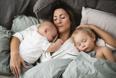 Mother lying in bed with sons