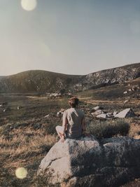 Rear view of people on rock against sky