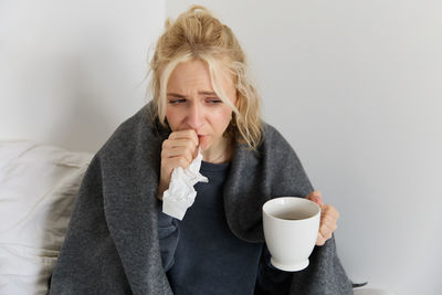 Young woman drinking coffee at home