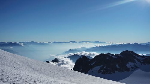 Scenic view of snow covered mountains against blue sky at the base of the augille de tour.