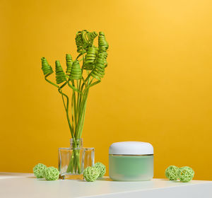 Green jar for cosmetics on a white table. packaging for cream, gel, serum, advertising and product 