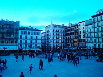 Panoramic view of people in city against blue sky