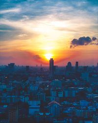 Aerial view of buildings in city during sunset