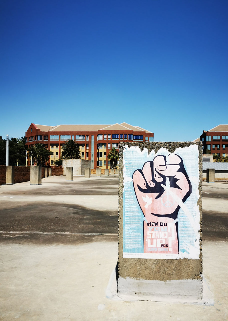 built structure, sky, architecture, clear sky, building exterior, communication, blue, text, copy space, day, nature, sign, no people, building, western script, city, sunlight, representation, outdoors, art and craft