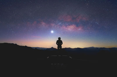Silhouette man standing against sky at night