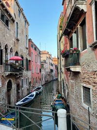 Canal amidst buildings in city against clear sky