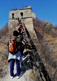 Low angle view of people walking on stone wall