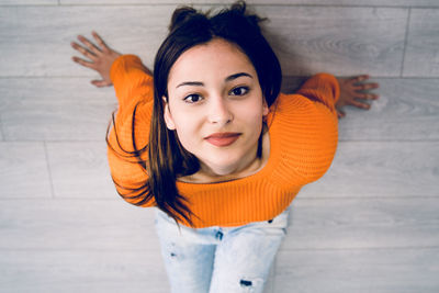 Portrait of smiling teenage girls sitting on hardwood floor