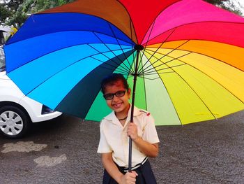 Portrait of smiling girl holding colorful umbrella