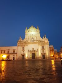 Low angle view of illuminated building against blue sky