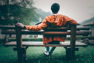 Rear view of man sitting on bench