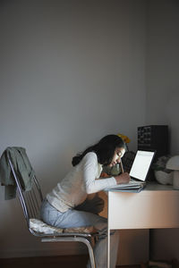 Girl doing homework with laptop