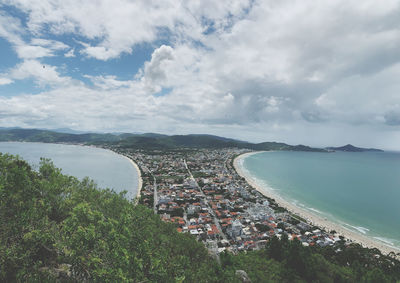 High angle view of town by sea against sky