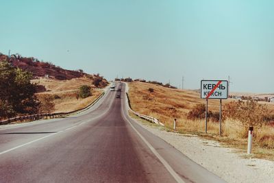 Empty road along landscape against clear sky