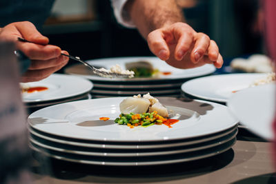 Close-up of man preparing food in plate