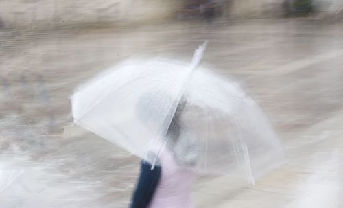 Blurred motion of woman walking on wet rainy day