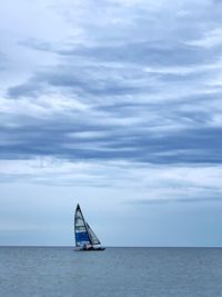 Sailboat in sea against sky