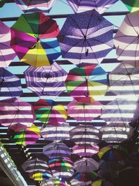 Low angle view of colorful umbrellas hanging against sky