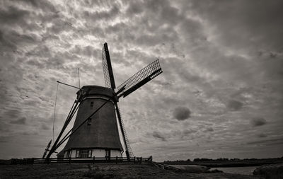 Traditional windmill on field against sky