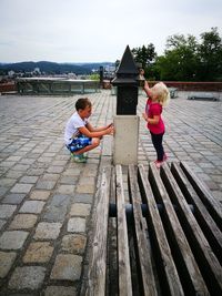 Boy playing with umbrella against sky