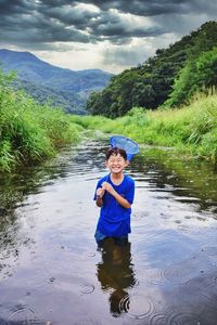 Portrait of boy with fishing net in water