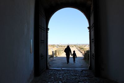 Silhouette people walking in corridor of historic building