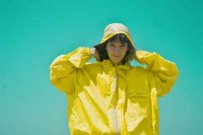 Low angle view of woman standing against clear blue sky