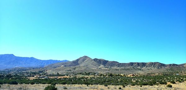 Scenic view of landscape and mountains against clear blue sky