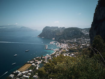 Aerial view of city by sea against sky